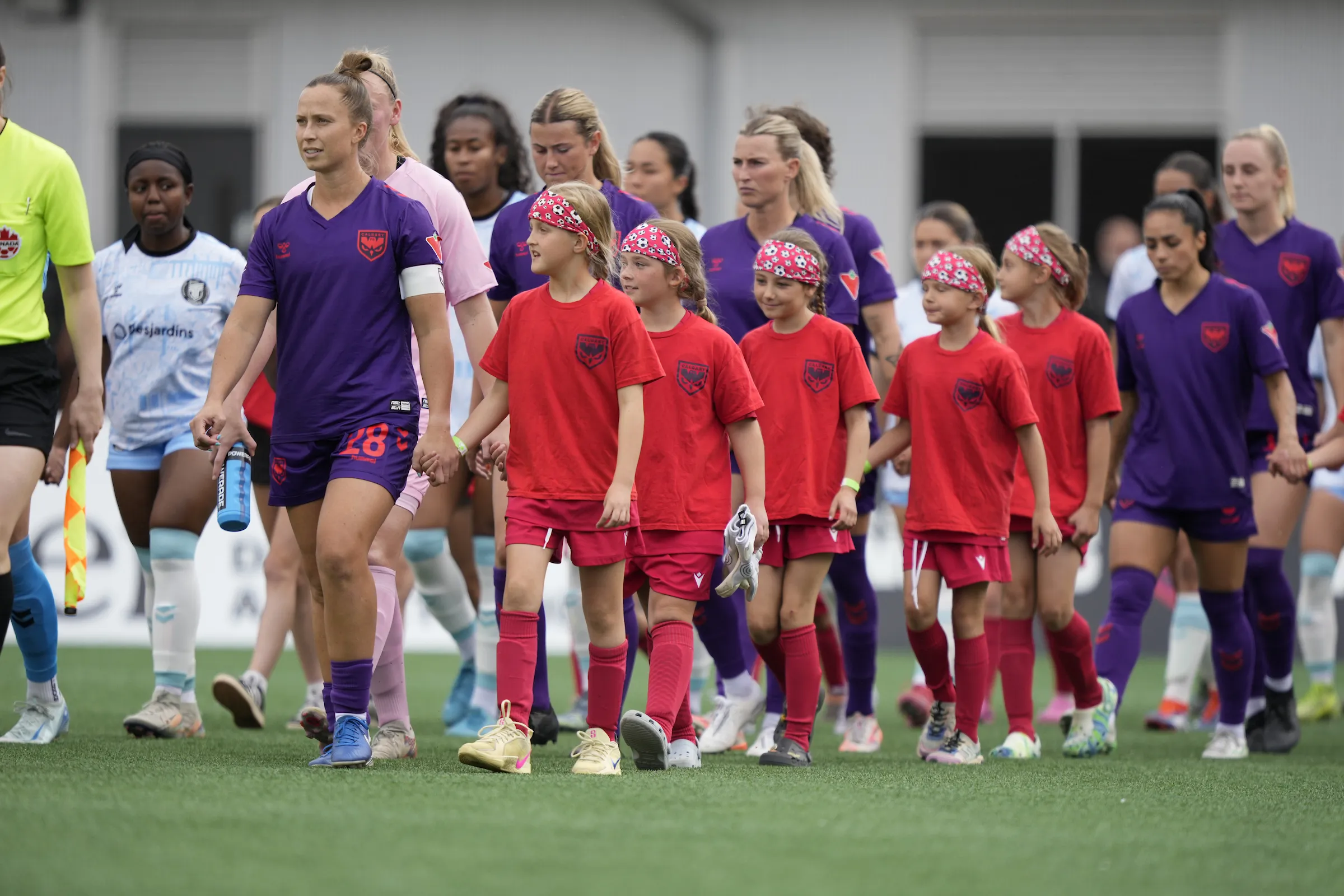 Kids walking out onto the pitch with players