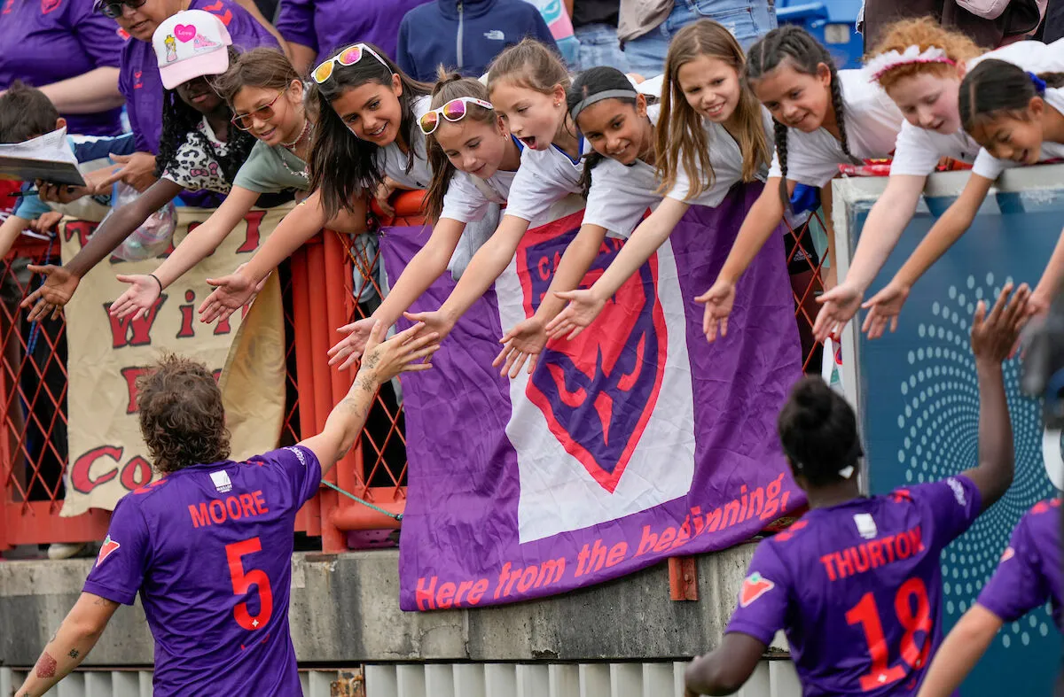 Kids giving high fives to players on the pitch