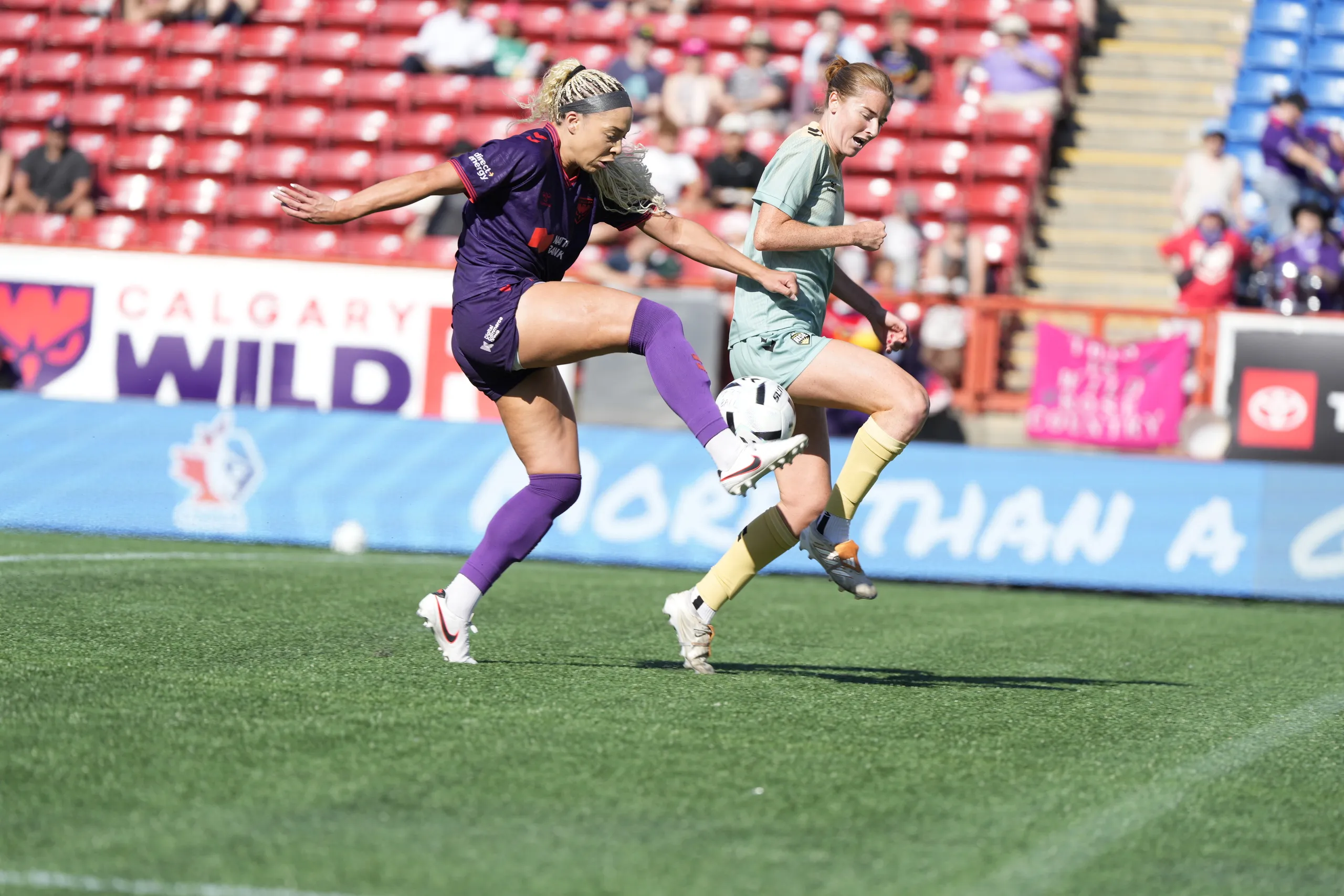 Jorian Baucom challenges a Vancouver Rise FC player at McMahon Stadium